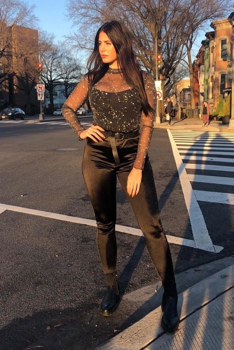A customer's review photo of themselves wearing the top with black pants and a belt