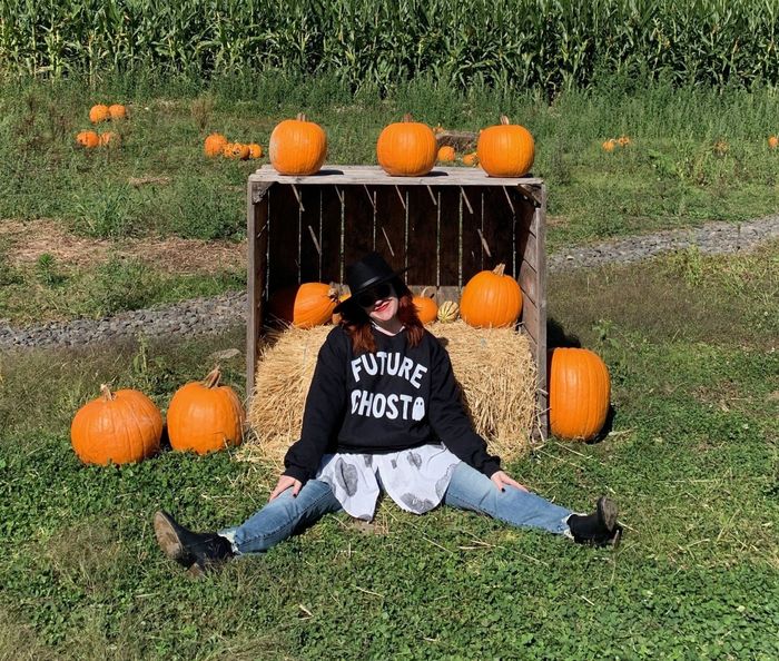 a Mytour writer in a pumpkin patch donning the sweatshirt