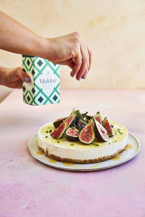 A model sprinkling the salt flakes over figs
