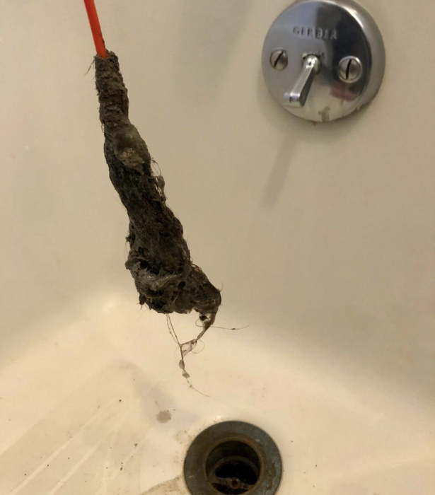 a reviewer demonstrating the amount of hair they extracted using the FlexiSnake