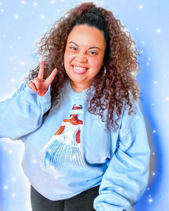 Mytour editor Kayla Boyd wearing a sweatshirt with an illustration of Brandy as Cinderella