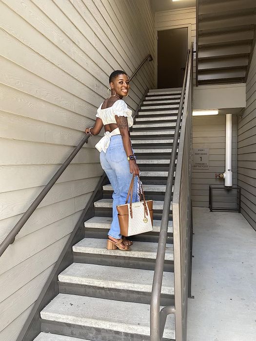 A reviewer posing from behind in the white crop top