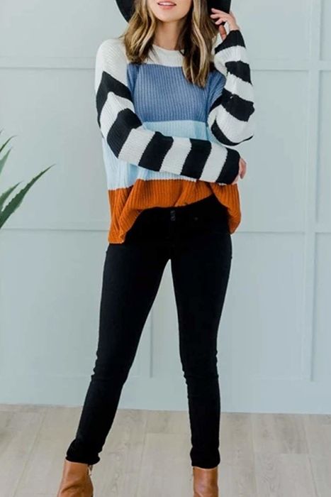 A model showcasing the pullover sweater featuring color-blocked design and black-and-white striped sleeves