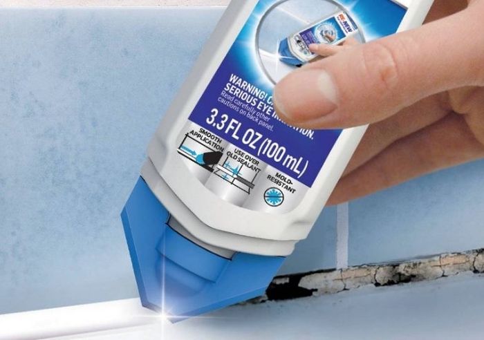 A person using caulk sealant