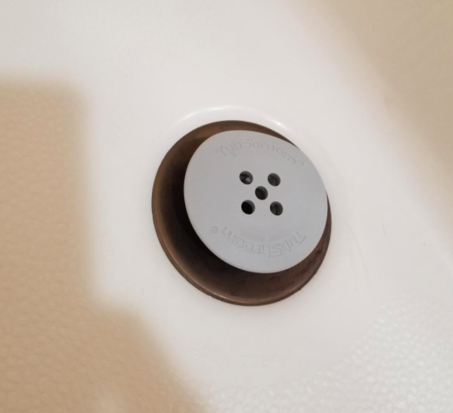 The TubShroom placed inside a reviewer's bathtub drain