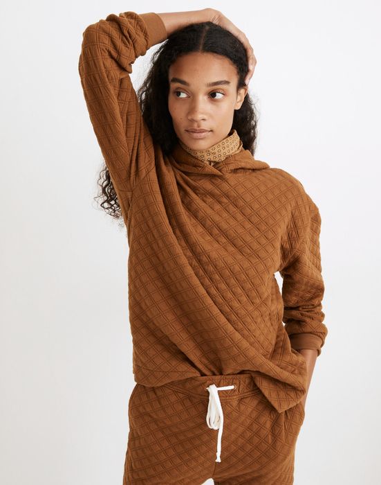 a model wearing a quilted dark orange sweatshirt