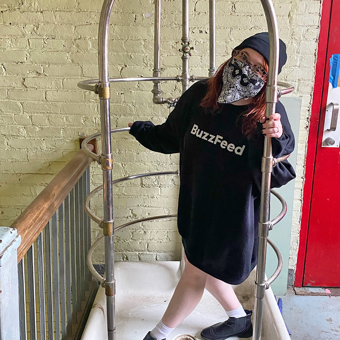 Mytour writer Mallory Mower rocking an oversized black sweatshirt with 'Mytour' written in white