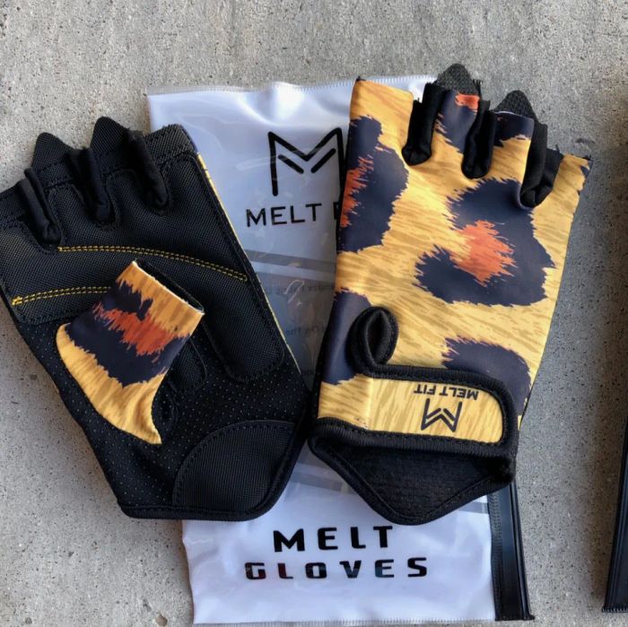 Cheetah-patterned athletic gloves displayed above their packaging on a cement surface.
