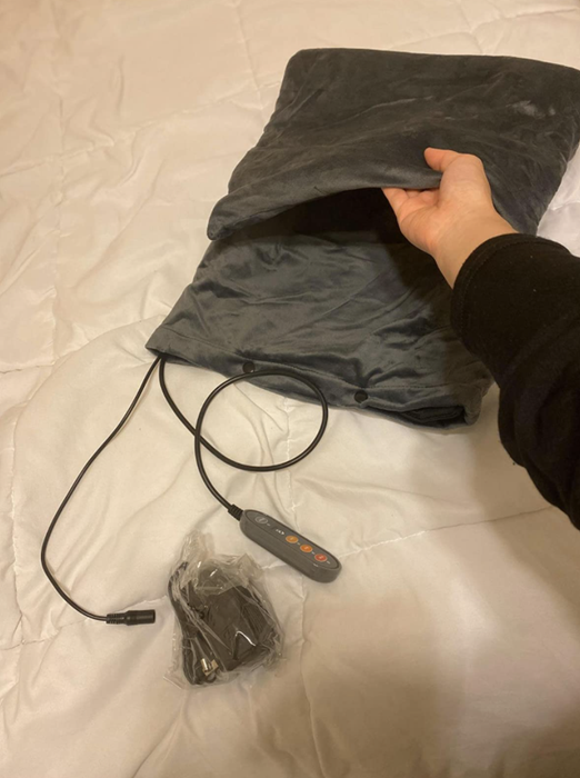 A reviewer demonstrates the use of a heating pad.