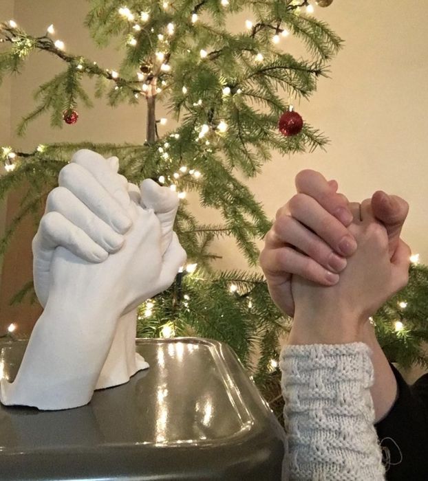 A cast of two hands intertwined, symbolizing the bond between a couple as they hold hands, creating a timeless keepsake.