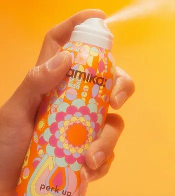 a model demonstrating the application of the dry shampoo spray