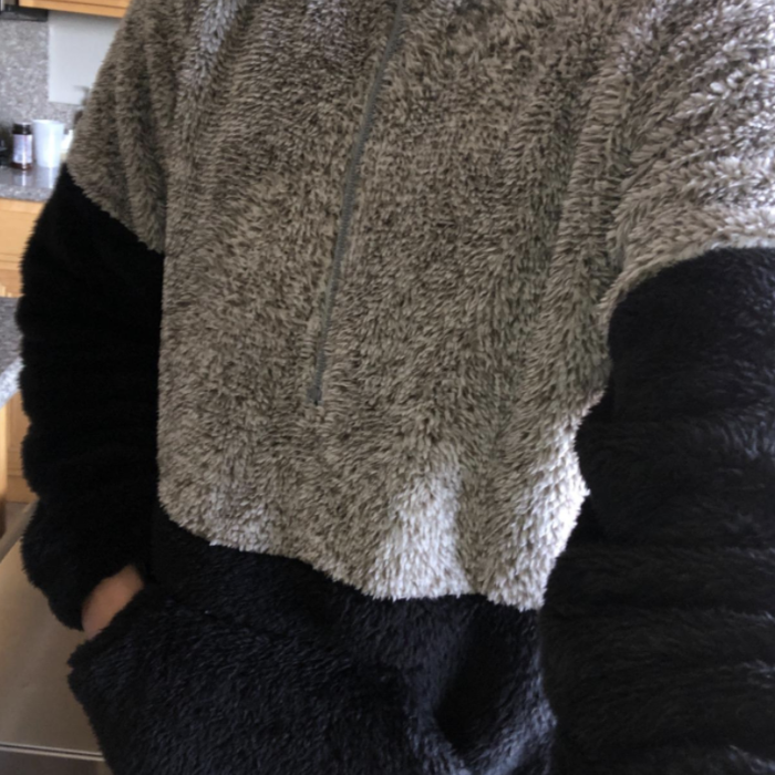 A reviewer is seen wearing a stylish white and black quarter zip.