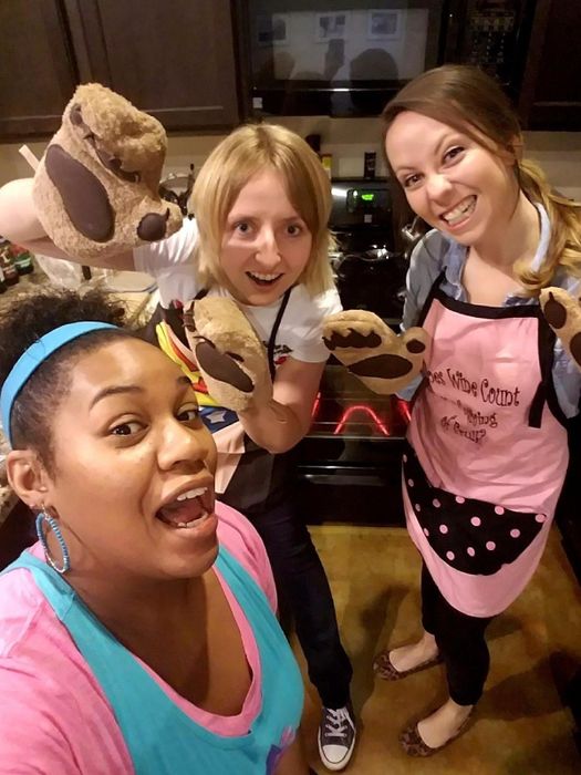 a group of women sporting oven mitts that mimic bear paws