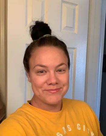 a reviewer demonstrating how the flyaways stay neatly in place after applying the hair finishing stick