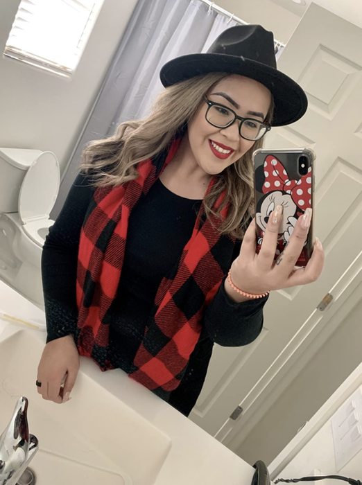 A reviewer models a red and black buffalo plaid scarf, adding a stylish touch to their outfit.