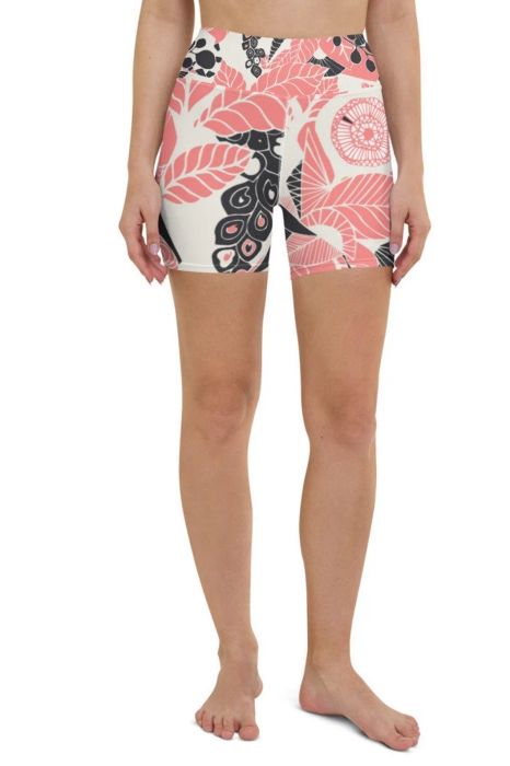 A model dressed in high-rise bike shorts featuring a white, pink, and black floral design.
