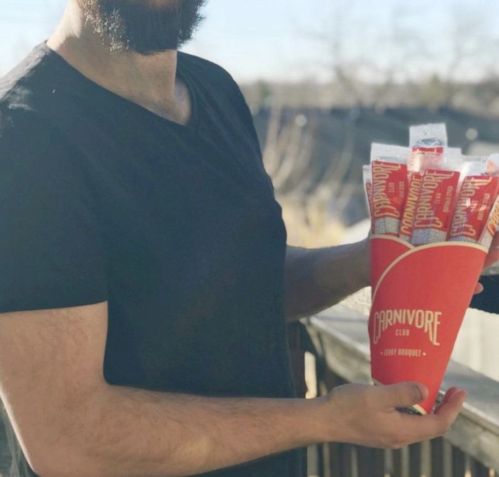 The spouse of a reviewer holding a jerky bouquet.