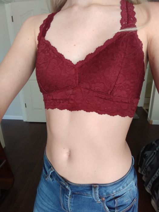 A reviewer modeling a red bralette