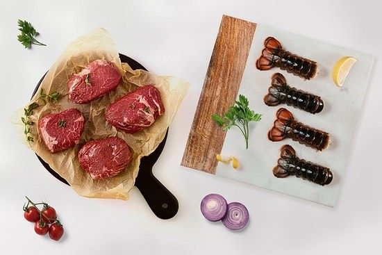 a dish featuring lobster tails alongside another with four perfectly grilled steaks