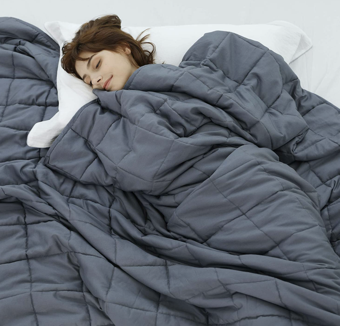 A person comfortably using a weighted blanket for relaxation.
