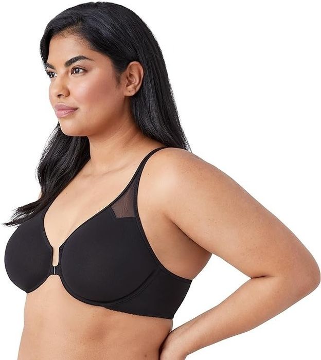 A model showcasing a black full-coverage bra with a front clasp and mesh accents near the straps. The image is featured in a shopping article