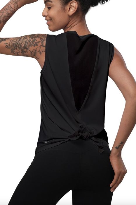 A person sporting a split-tail tank top paired with matching leggings