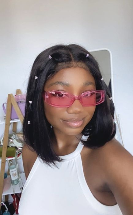 A reviewer wearing the sunglasses in a stylish pink frame.