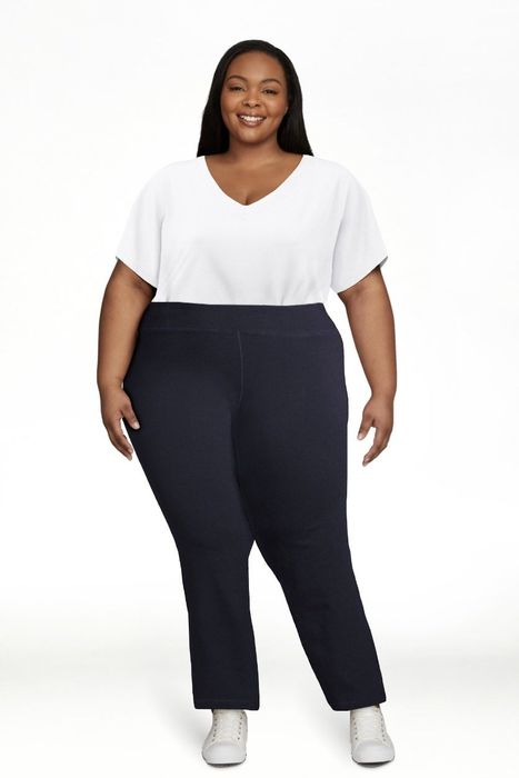A person wearing a white top and dark navy flared pants