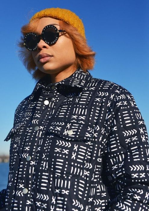 A model wears a mud black quilted jacket, combining warmth with elegance.