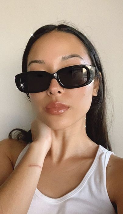 A reviewer wearing the sunglasses in a chic black frame.
