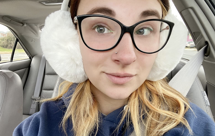 A reviewer pairs white ear muffs with their winter outfit for a polished look.