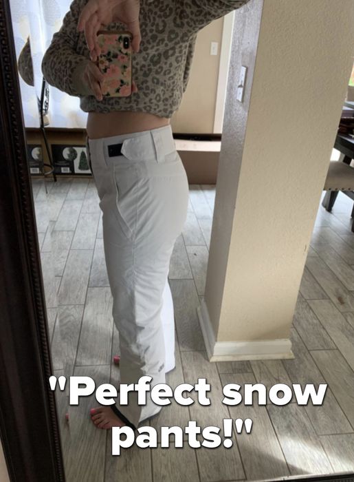 A reviewer takes a mirror selfie wearing stylish white pants.