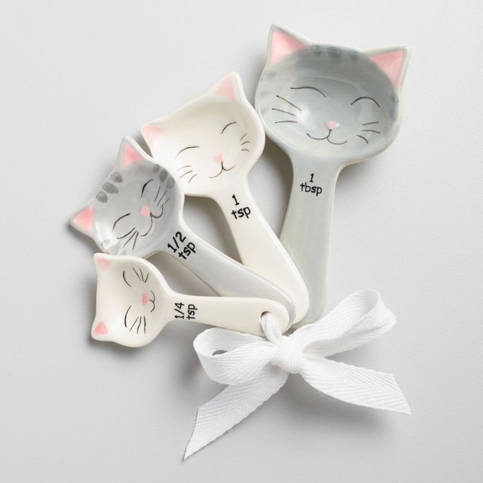 The measuring spoons feature adorable grey and white cats, all smiling cheerfully.