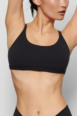 A model is seen wearing a black Skims bra paired with matching underwear