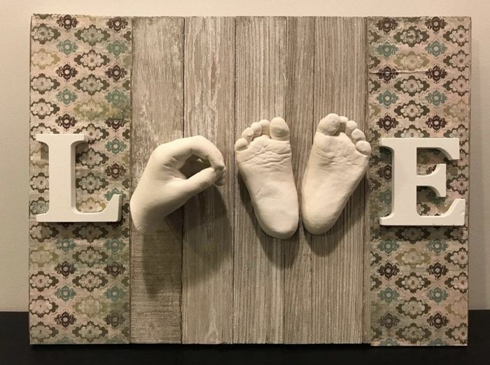 A sign reading 'love,' with the handprints and footprints of a child forming the 'o' and 'v,' offering a sentimental and personal touch.