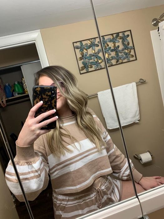 A reviewer showcases the loungewear set in a stylish striped apricot design.