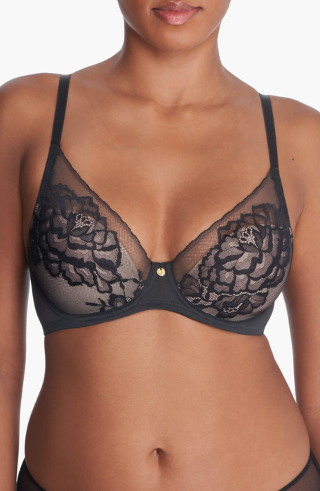 A model displays a lace bralette adorned with floral patterns and delicate adjustable straps. The bralette includes sheer mesh panels and an underwire for added support