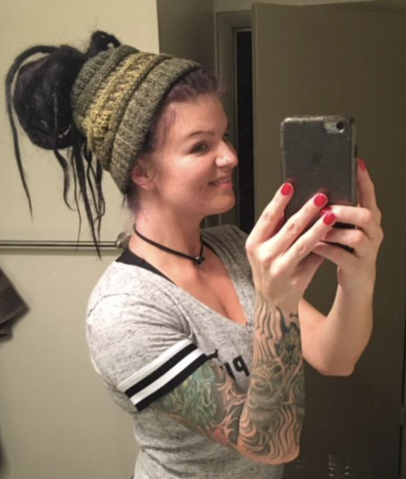 A reviewer demonstrates how to wear a hat with a bun.