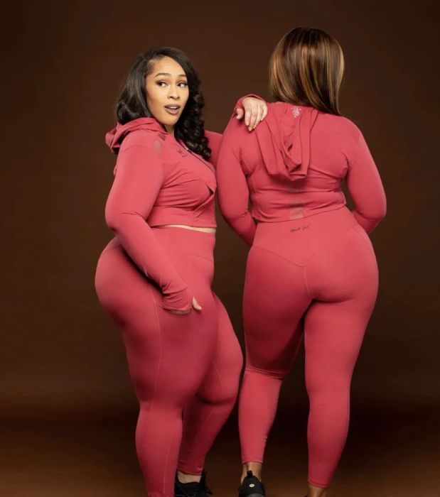 Models are dressed in coordinated red leggings and long-sleeve crop tops, showcasing a vibrant and cohesive athletic look.