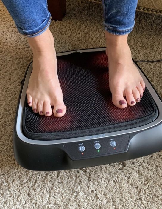 A person enjoying a relaxing moment with their feet resting comfortably on the foot massager, indulging in soothing relief.