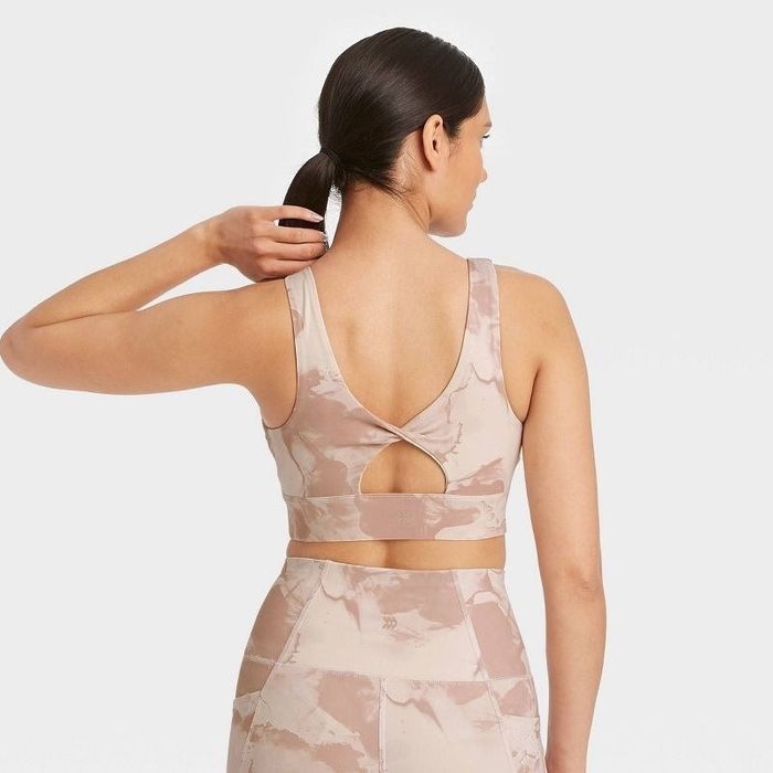 Model wearing the washed rose twist-back sports bra