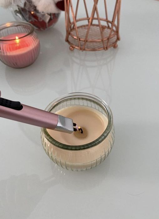 a reviewer lighting a candle with their electric lighter