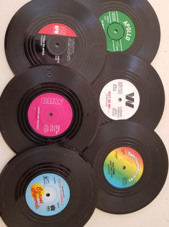 Six distinct mini vinyl records scattered across a table, waiting to be admired.