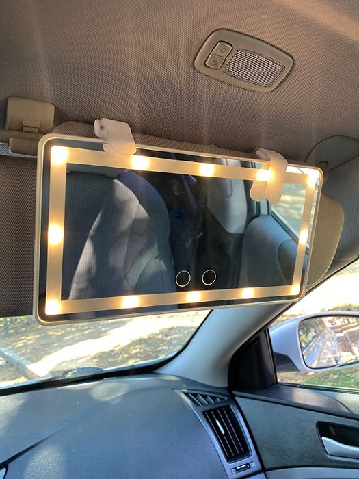 A reviewer's white mirror, illuminated and attached to their car’s sun visor