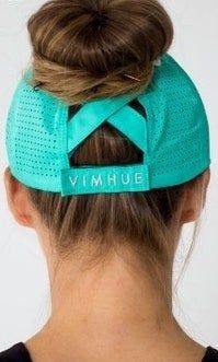 back view of a model wearing the green cap with their hair styled in a bun