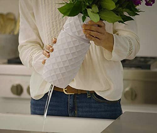 A model demonstrating how to twist open the base of a sleek white flower vase