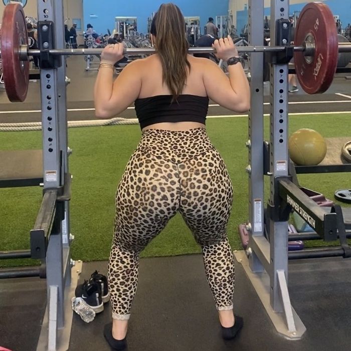 a rear view of a reviewer in leopard print leggings lifting weights