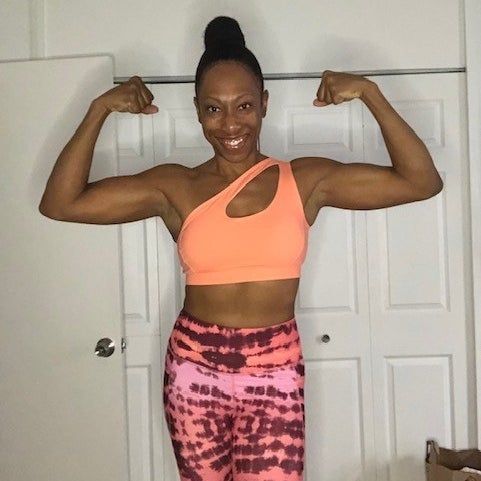 The reviewer is wearing an eye-catching orange sports bra.