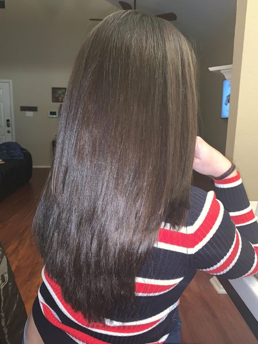 The reviewer’s hair after using the Herstyler serum, now looking sleek, shiny, and frizz-free.