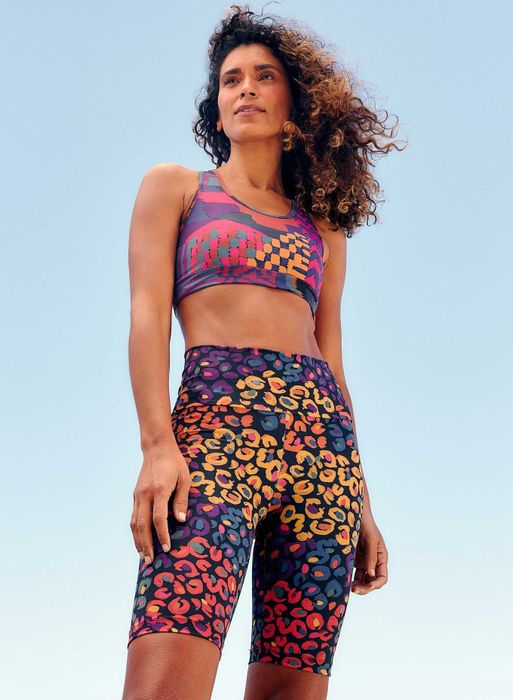 A model rocks a pair of multicolored bike shorts, adding a vibrant touch to their activewear look.